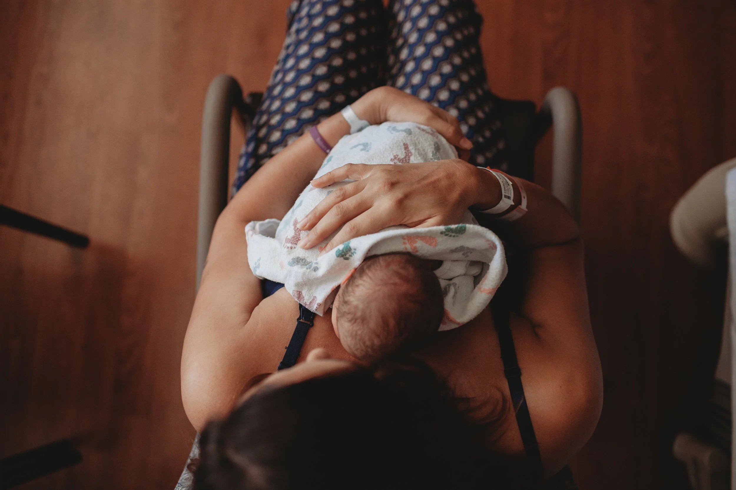 A parent cradling a newborn against their chest